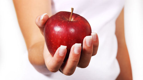Czerwone jabłko trzymane w dłoni