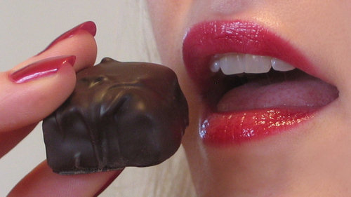 Kobieta zjadająca czekoladkę