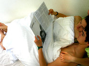 Para czaytająca gazetę w łóżku
