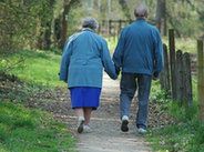 Para staruszków spacerujących po lesie