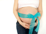 Ciążowy brzuch przewiązany wstążką