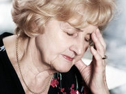 Starsza babcia cierpiąca na ból głowy