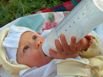 Noworodek pijący mleko z butelki